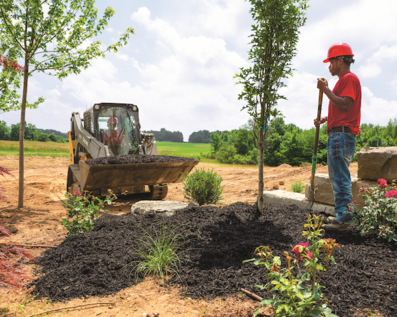 Landscaper using the 317G Compact Track Loader to plant