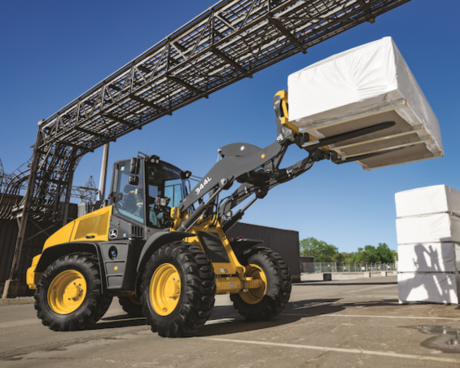 A 344L Compact Loader transporting material at a warehouse