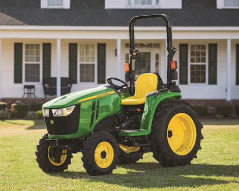 A John Deere 3025E sitting in the front yard