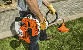 Man using his Stihl Trimmers to cut down his grass