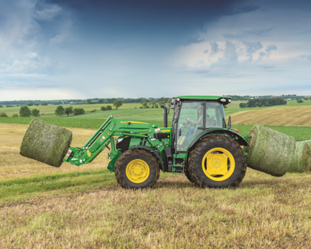 A John Deere 511R Utility Tractor hauling bales of hay
